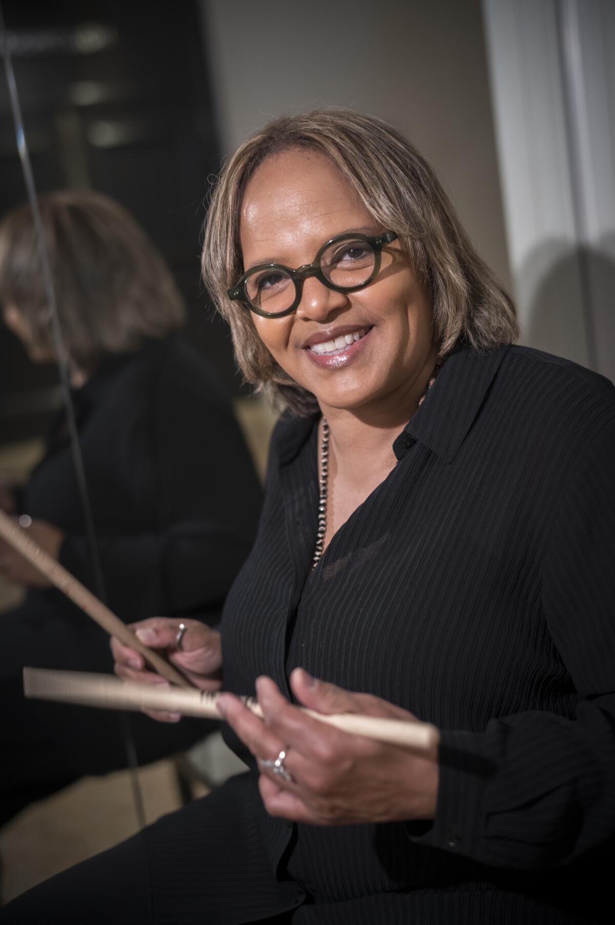 Terri Lyne Carpenter holding a pair of drumsticks