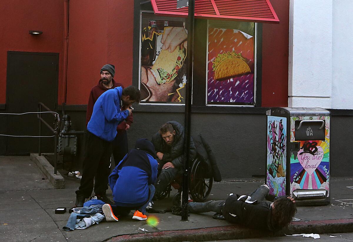 San Francisco, CA - A group of men loiter and use drugs outside a fastfood restaurant in the Tenderloin district of San Francisco. The Tenderloin is a high crime area known for open sales and use of illegal drugs as well thousands of unhoused living on the streets. One of the world's premier cities, San Francisco now has a dubious reputation for intractable homelessness, rampant crime and an exodus of business. (Luis Sinco / Los Angeles Times)