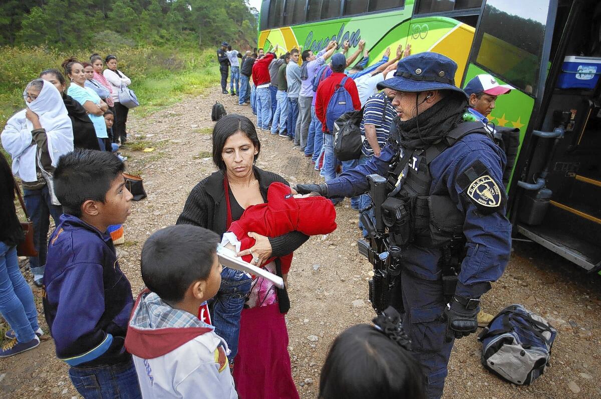 Miguel Martinez Madrid speaks with a mother who was pulled off a Guatemala-bound bus at a roadblock near Ocotepeque, Honduras, in July.