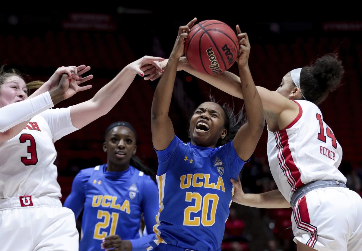 UCLA guard Charisma Osborne (20) pulls in a rebound between Utah' Andrea Torres (3) and Niyah Becker (14) during a game in Salt Lake City on Jan. 10.