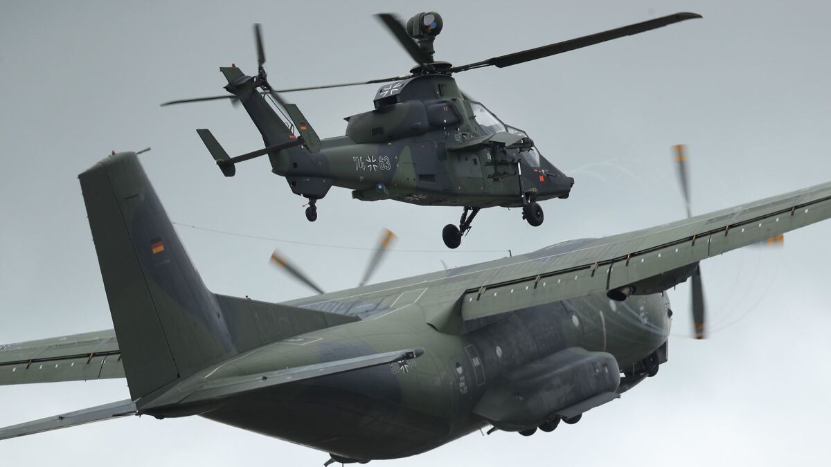A Transall C-160 transport plane and a Eurocopter Tiger attack helicopter of the Bundeswehr, the German armed forces, participate in the ILA Berlin Air Show on April 25.