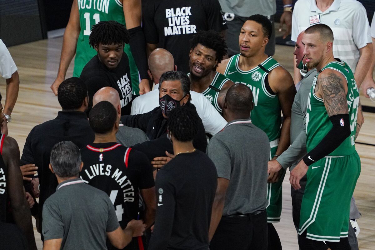 Boston Celtics guard Marcus Smart (36) exchanges works with members of th eToronto Raptors following an NBA conference semifinal playoff basketball game Wednesday, Sept. 9, 2020, in Lake Buena Vista, Fla. The Raptors defeated the Celtics 125-122. (AP Photo/Mark J. Terrill)