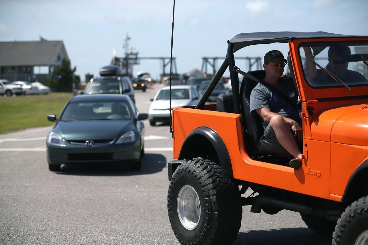 Vehicles drive off the ferry from Ocracoke Island, N.C., where officials have called for voluntary evacuations due to approaching Tropical Storm Arthur.