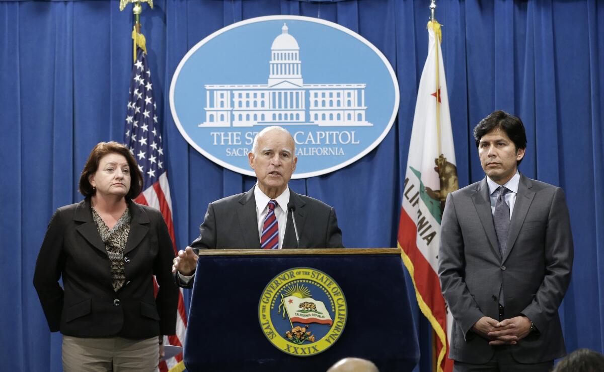 Calif. Gov. Jerry Brown, flanked by Assembly Speaker Toni Atkins, D-San Diego, left, and Senate President Pro Tem Kevin de Leon, D-Los Angeles, announced scaling back their climate change proposal during a Sept. 9 news conference in Sacramento.
