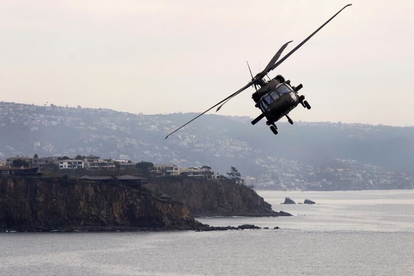 A UH-60 Blackhawk helicopter flies along the Orange County coast during the California National Guard's annual "Boss Lift" providing free rides to about 80 employers of National Guard soldiers as a thank you for giving them time off work to train and deploy overseas on Friday, December 6, 2019. ///ADDITIONAL INFO: tn-wknd-et-blackhawk-20191206 12/6/19 - Photo by DREW A. KELLEY, CONTRIBUTING PHOTOGRAPHER