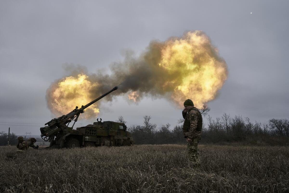 Ukrainian soldiers fire a self-propelled howitzer towards Russian positions.