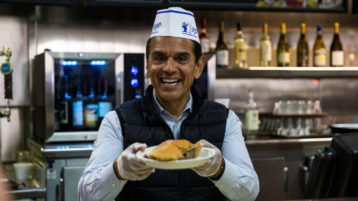 Former L.A. Mayor Antonio Villaraigosa serves food at Philippe's in downtown during a 24-hour campaign sprint through the city last week.