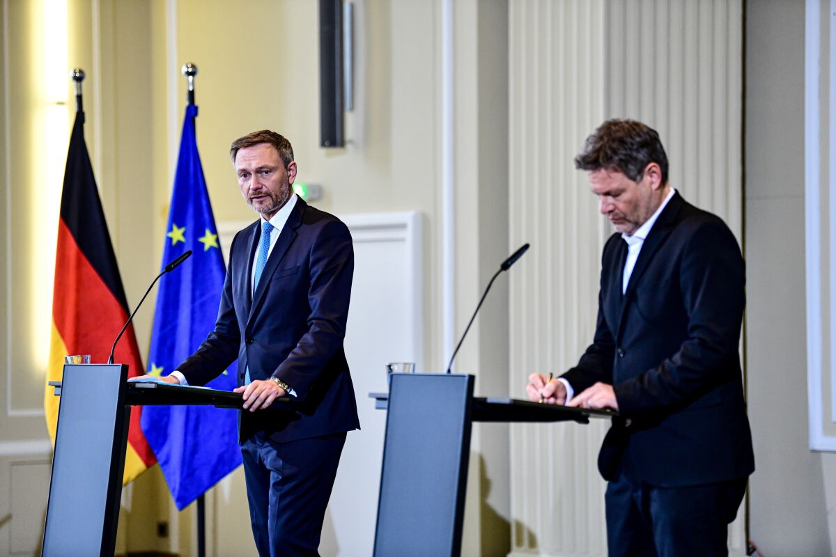 Robert Habeck, right, Federal Minister for the Economy and Climate Protection, and Christian Lindner, Federal Minister of Finance, attenda press conference and present a company aid package agreed by the government in Berlin, Germany, Friday, April 8, 2022. (Fabian Sommer/dpa via AP)