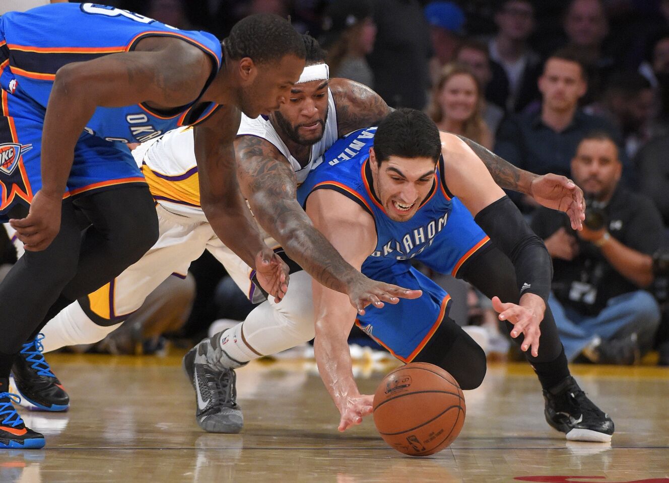 Thunder center Enes Kanterdives to the floor for a loose ball in front of teammate Dion Waiters and Lakers center Jordan Hill during the second half.