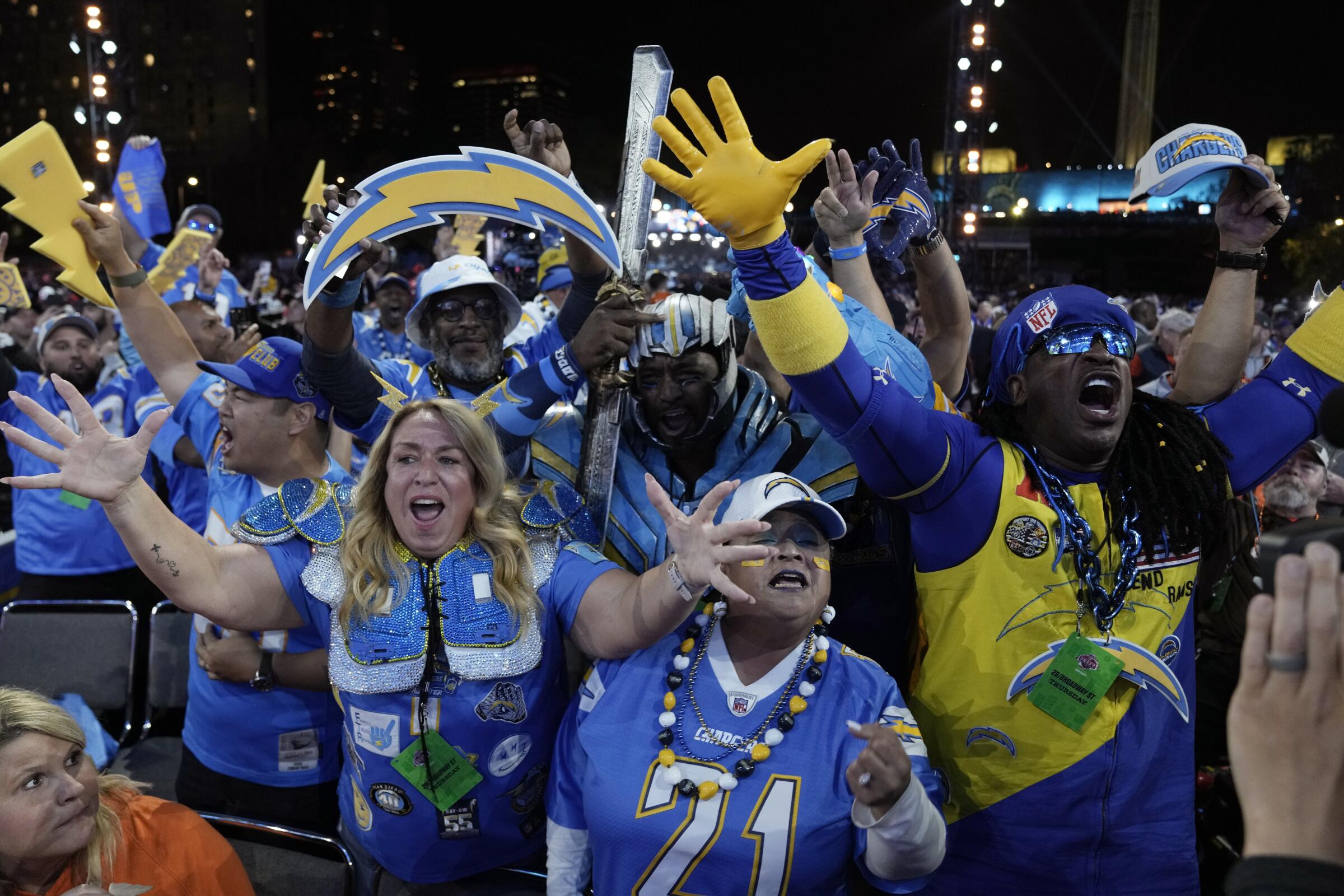 Chargers fans in Kansas City celebrate during the first round of the NFL draft on Thursday.