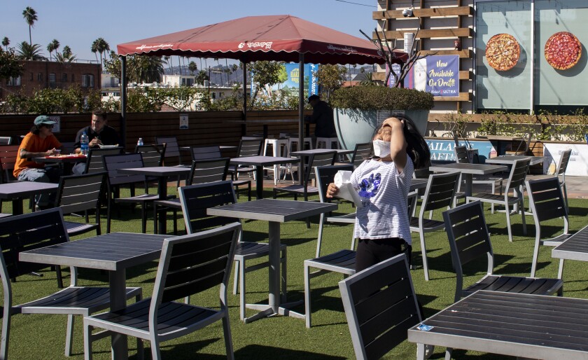 A young girl runs through the seating area at the food court on the rooftop at the California Market in Los Angeles.