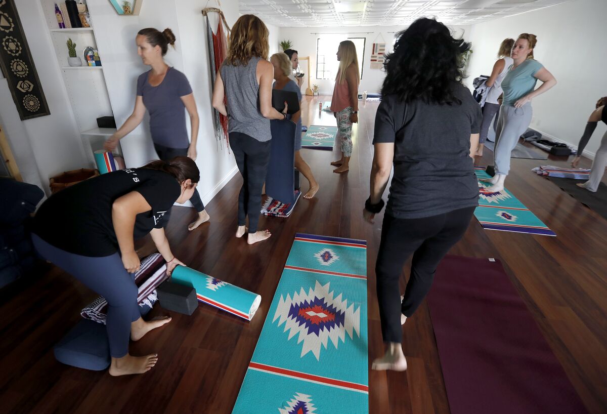 Clients arrive and place their mats for a light yoga session at Alison Zimmer's Zen Den in Huntington Beach.