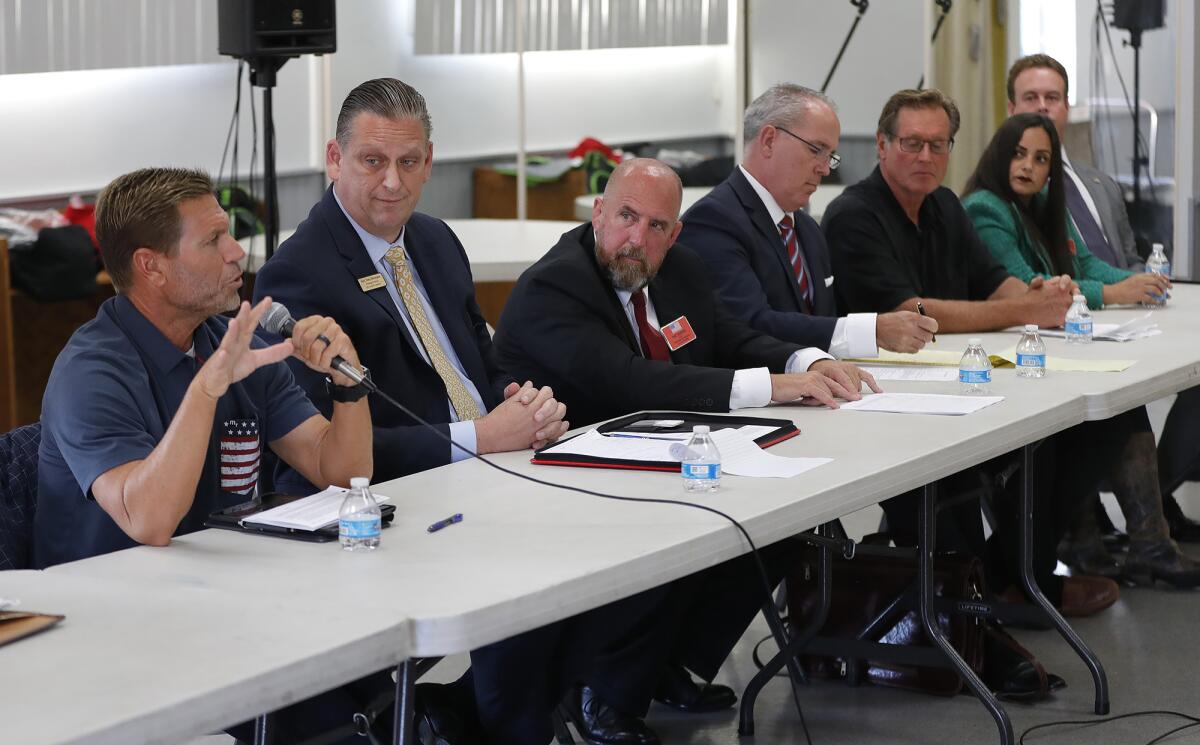 Candidates answer an audience questions including Michael Olsberg, with microphone.