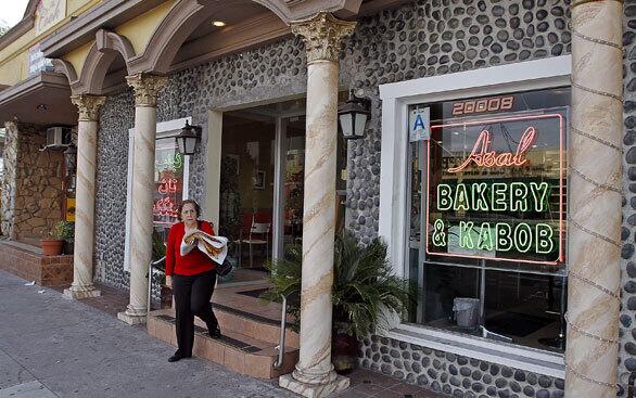 A customer leaves the Asal Bakery and Kabob in Woodland Hills with an armload of sangak, a flatbread popular in Iran.