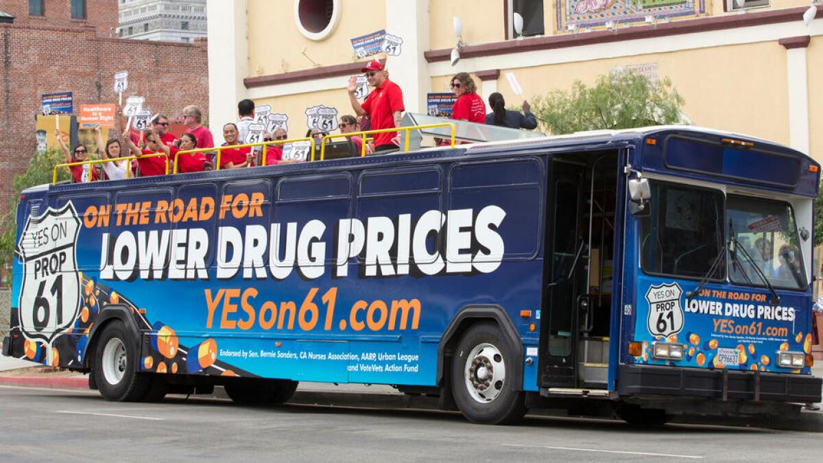 Supporters of Proposition 61 gather atop a double-decker bus in downtown Los Angeles.