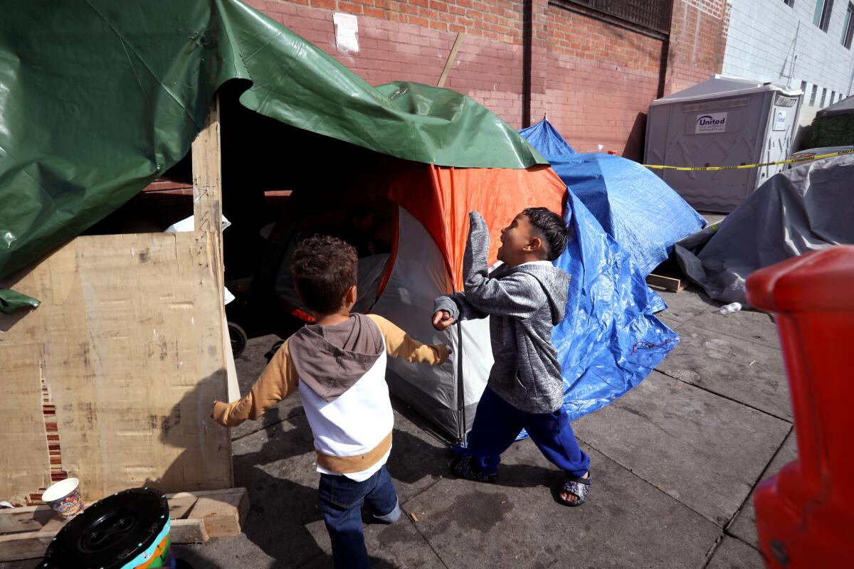 A migrant children play in front of their family's tent.