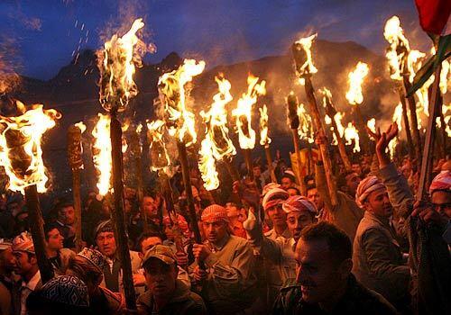 CELEBRATION: Iraqi Kurds carry torches as they mark the New Year celebration of Nowruz in the town of Akri, about 300 miles north of Baghdad. Nowruz, celebrated at the arrival of spring, is rooted in Kurdish folklore.