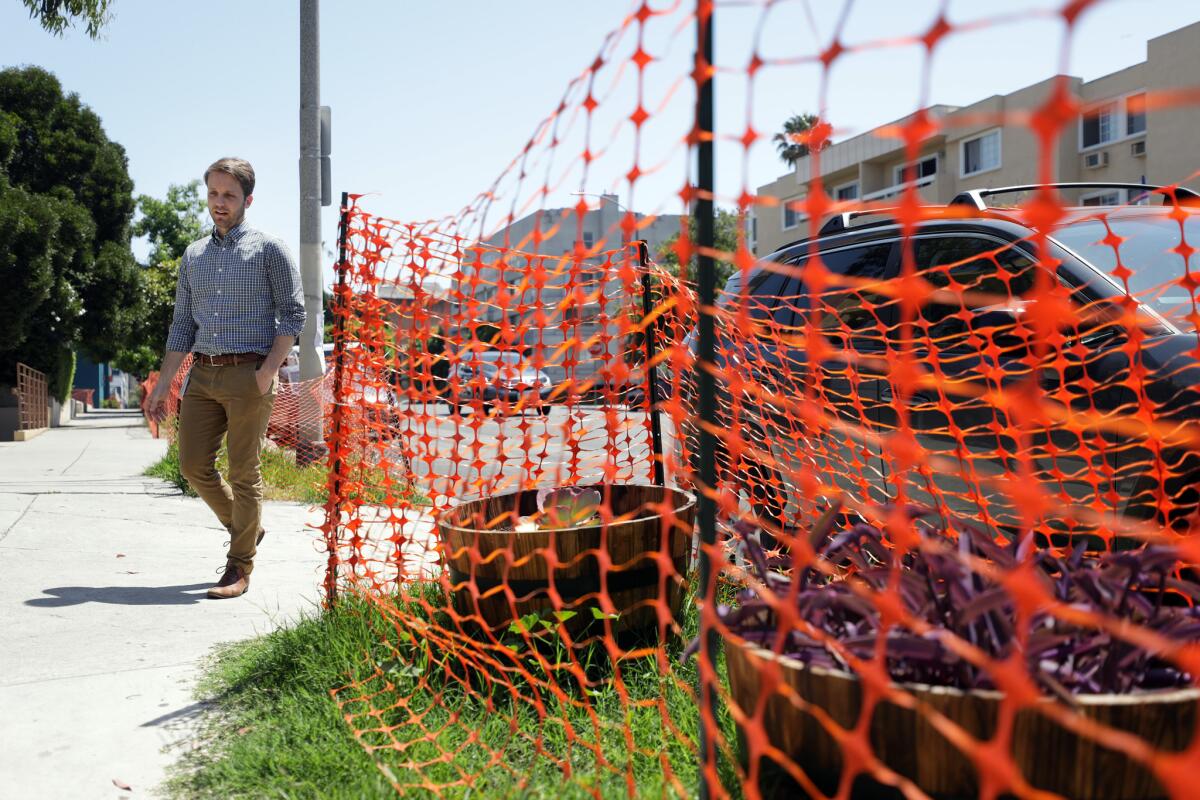 Chris Homandberg, a volunteer with KTown for All, shows areas around Koreatown where planters, fencing and other obstacles have been placed by property owners to keep the homeless from camping along the sidewalk, such as at this location on Westmoreland Avenue near 5th Street.