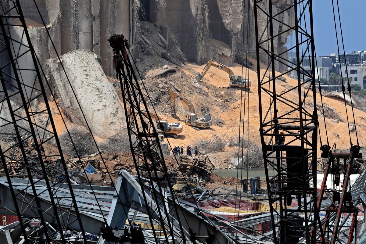 Rescuers use excavators to clear rubble at site of damaged grain silos in Beirut