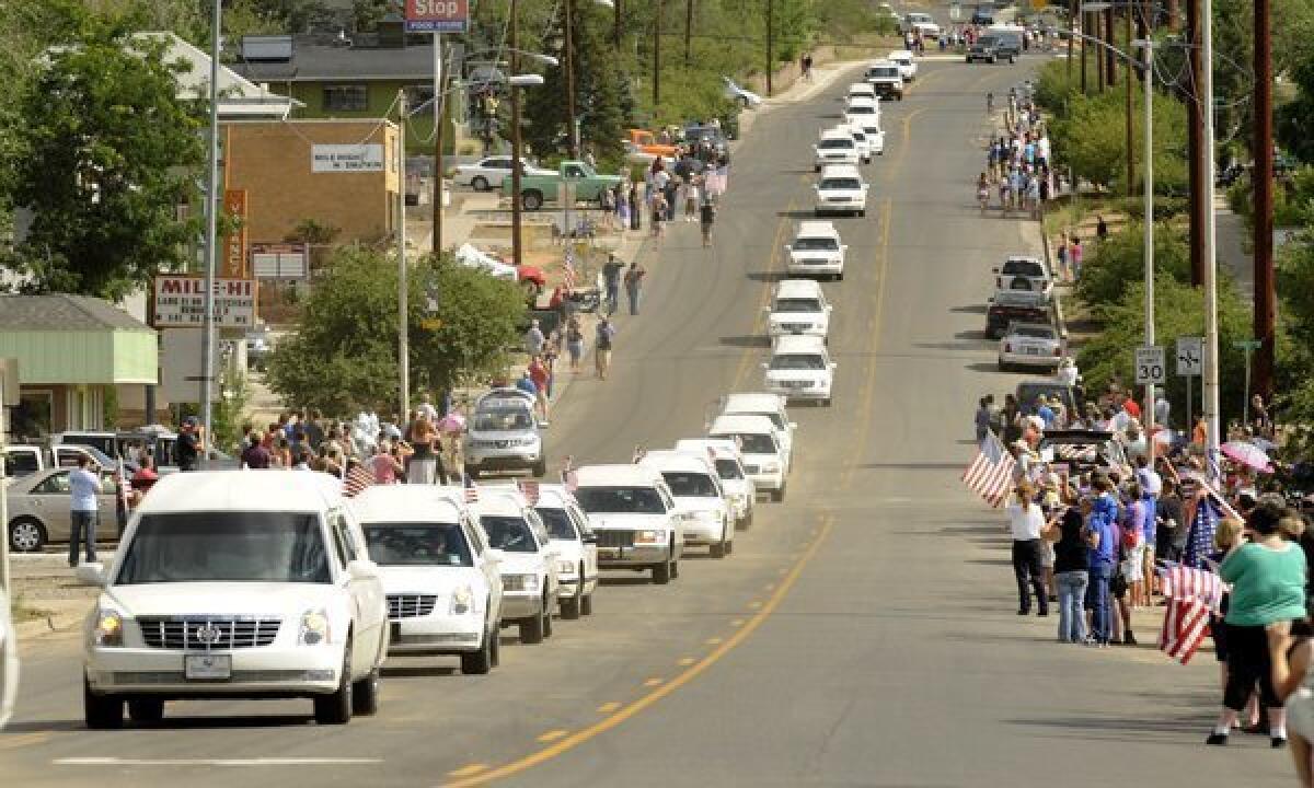 A procession carrying 19 firefighters in separate hearses make there way into Prescott during a procession from Phoenix Sunday.