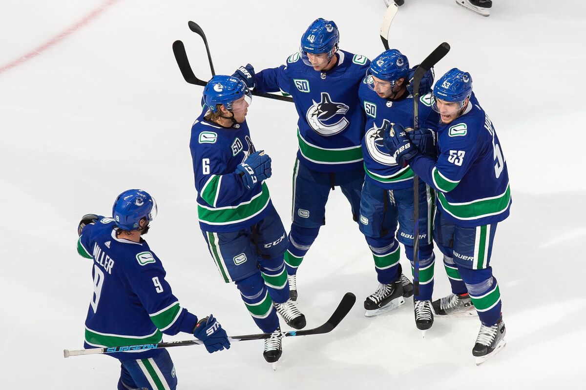 Vancouver Canucks' J.T. Miller (9), Brock Boeser (6), Elias Pettersson (40), Quinn Hughes (43) and Bo Horvat (53) celebrate a goal against the Minnesota Wild during the third period of an NHL hockey playoff game in Edmonton, Alberta, Tuesday, Aug. 4, 2020. (Codie McLachlan/The Canadian Press via AP)