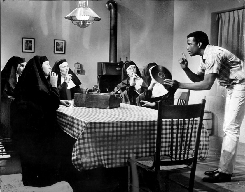 Sidney Poitier talks to a group of seated nuns.