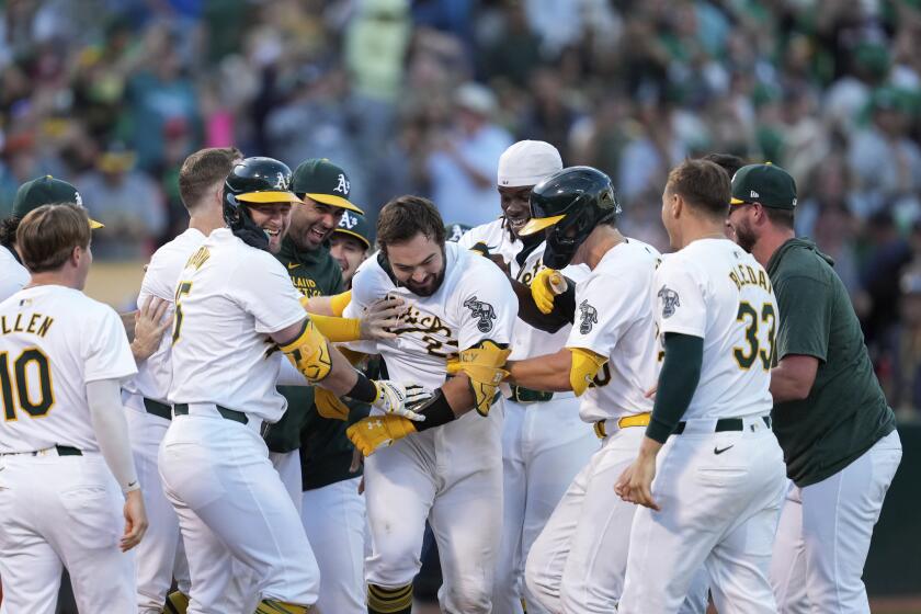 Shea Langeliers, centro, de los Atléticos de Oakland, es felicitado por sus compañeros de equipo después de conectar un jonrón ganador en solitario contra los Marineros de Seattle en un juego de béisbol del lunes 2 de septiembre de 2024 en Oakland, California. (Foto AP/Godofredo A. Vásquez)