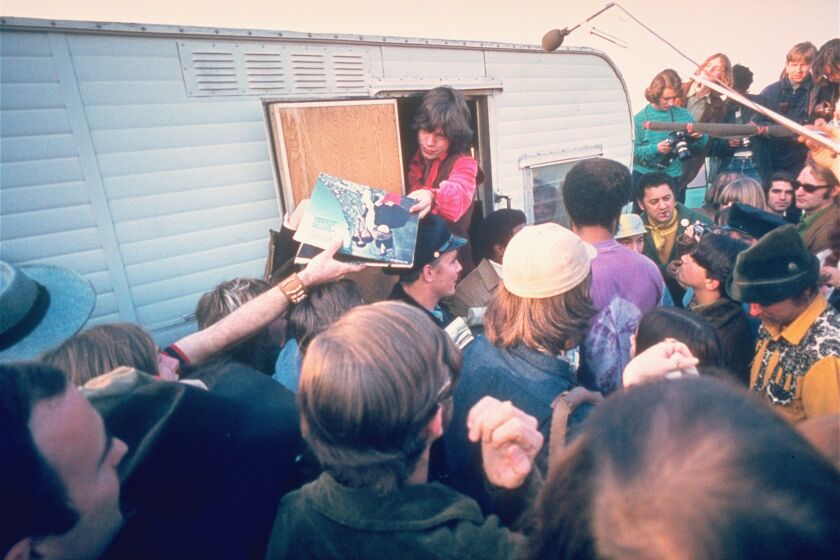 The Rolling Stones lead singer Mick Jagger signs autographs for fans at the Altamont Race Track, Dec. 8, 1969. Later, the Stones gave a concert where one fan was stabbed to death by a Hells Angels member. (AP Photo)