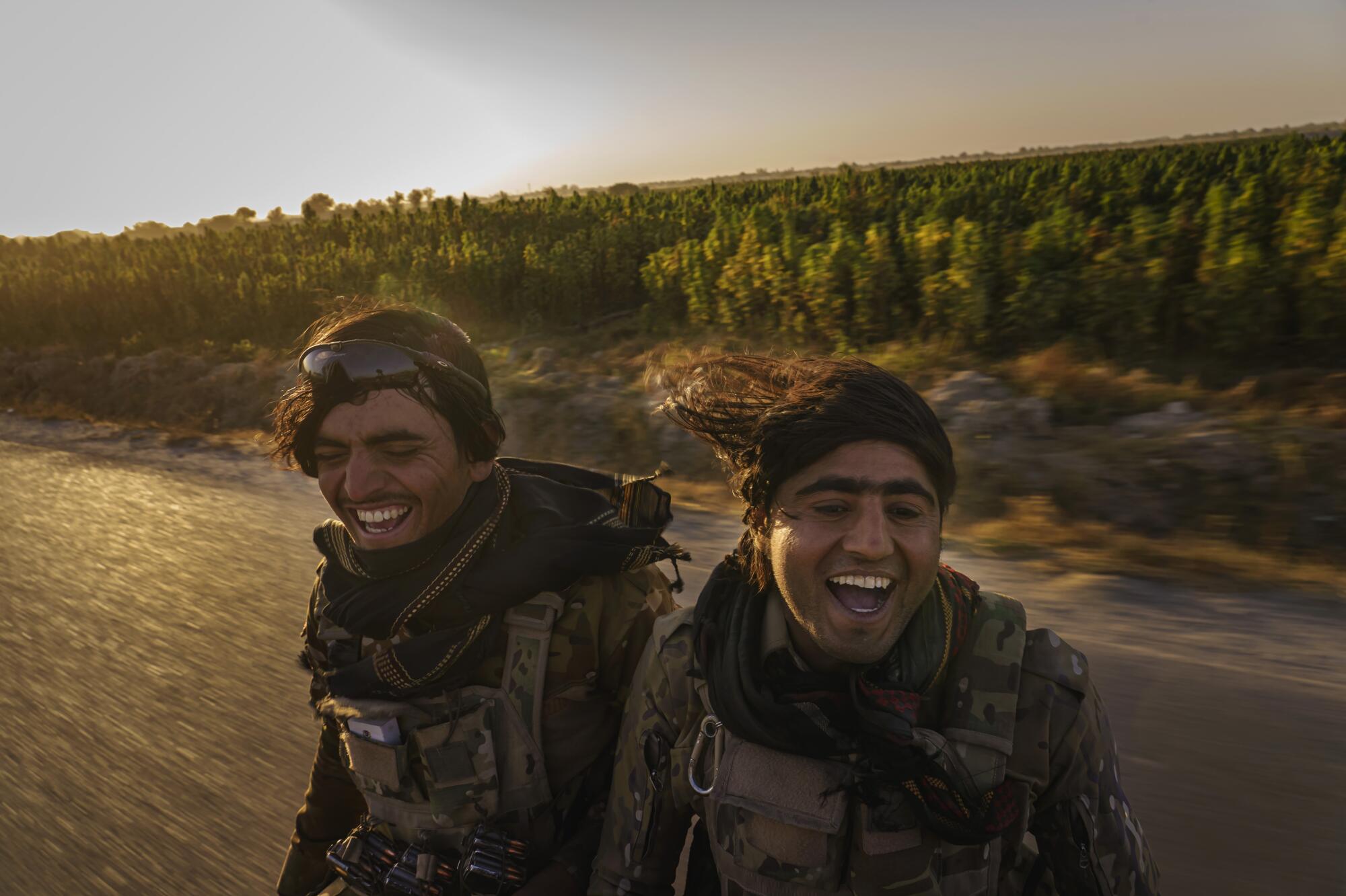 Two men ride in a moving vehicle, smiling and singing.