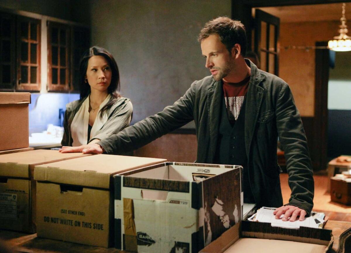 Jonny Lee Miller and Lucy Liu in a scene from CBS' "Elementary," one of at least 18 series being renewed by CBS.