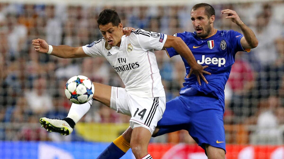 Real Madrid forward Javier Hernandez receives a pass while defended by Juventus' Giorgio Chiellini during their Champions League game on Wednesday.