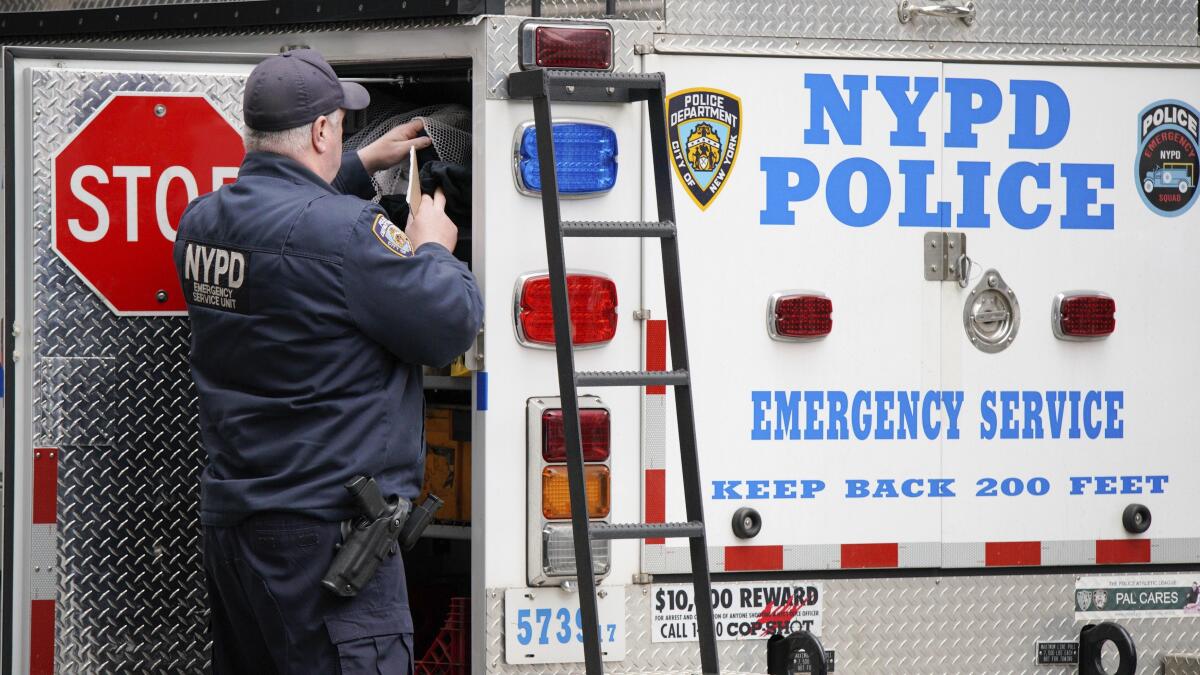 A New York Police Department officer stands next to an emergency truck