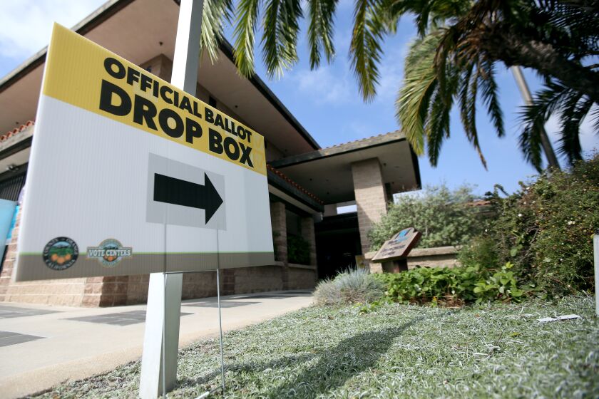 A sign points to an official ballot box located a little out of view and near the front door of the Mesa Water District, in Costa Mesa on Wednesday, Oct. 21, 2020.