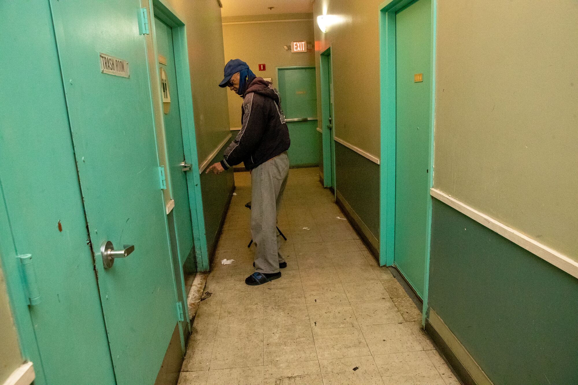 A man in a hallway of a residential building
