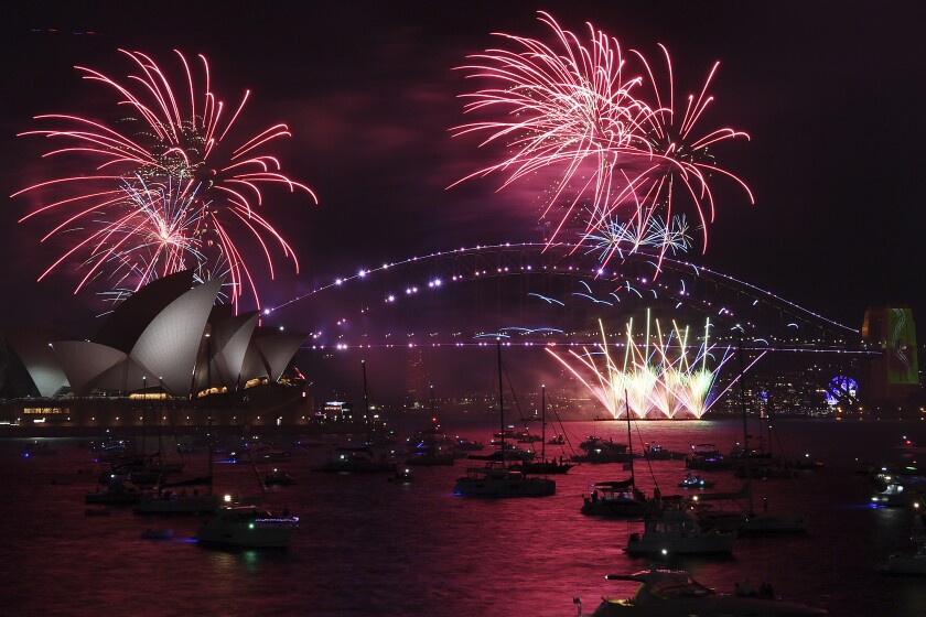 Fuegos artificiales iluminan el puente y la ópera de Sydney en el inicio de los festejos de Año Nuevo,