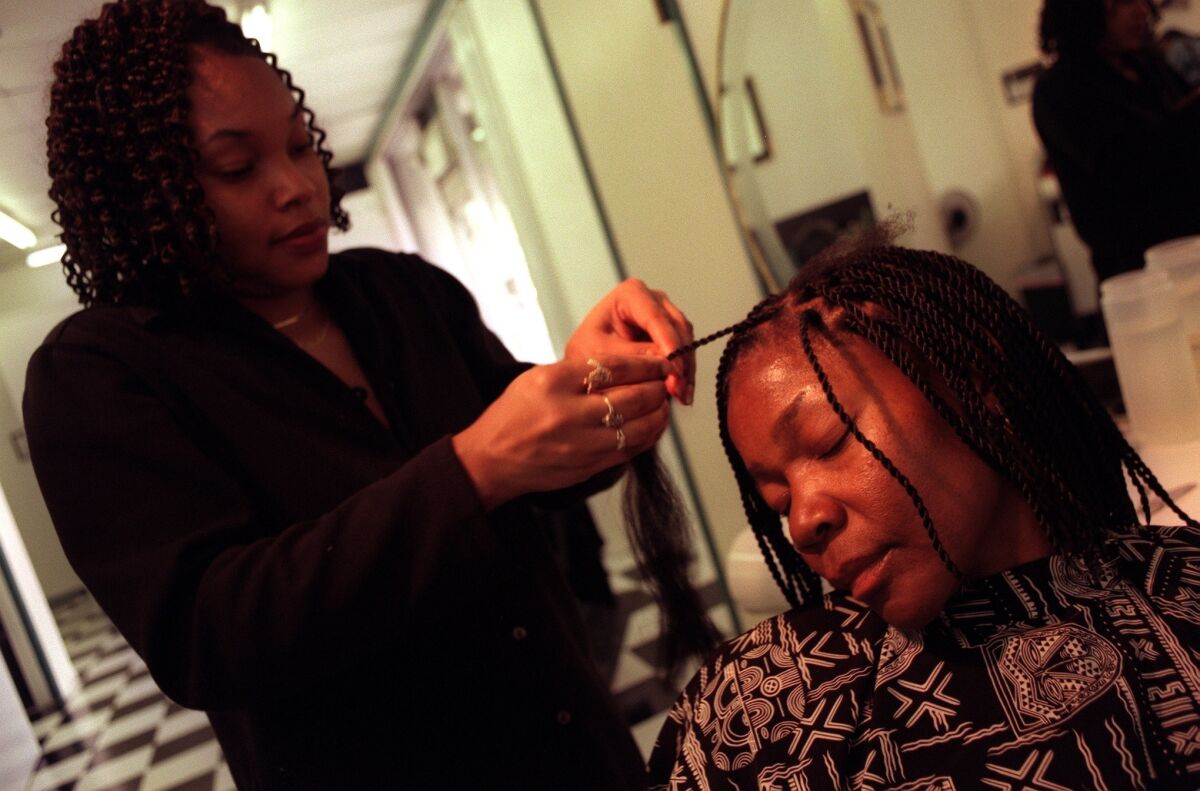 Hair stylist Keeshone Cook puts the finishing touches on Letta Semenya's braids at the Nubian Creations Salon in Pasadena. The TSA says it does not target the hair of black women for pat down searches.