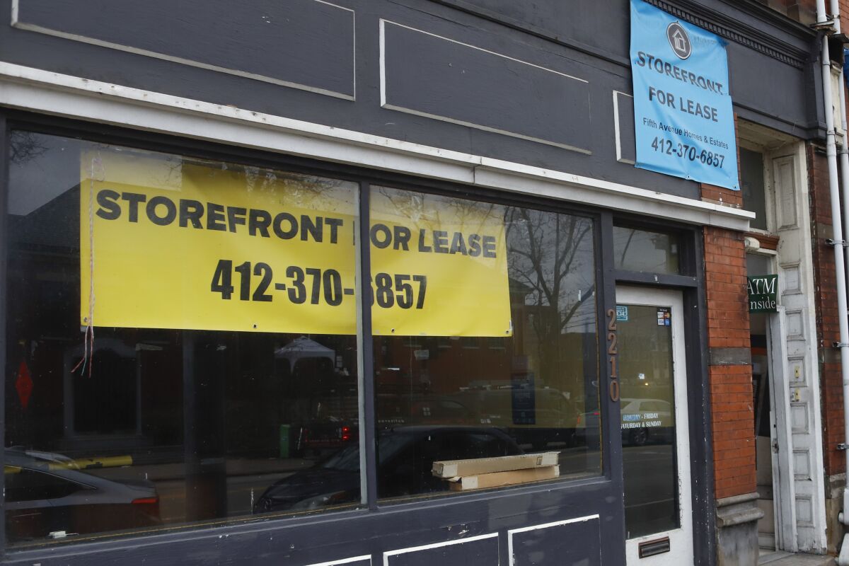 A banner inside a storefront window says "Storefront for lease."