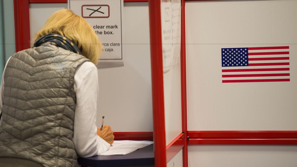 A voter casts her ballot at an absentee voting station in Arlington, Va., on Wednesday.