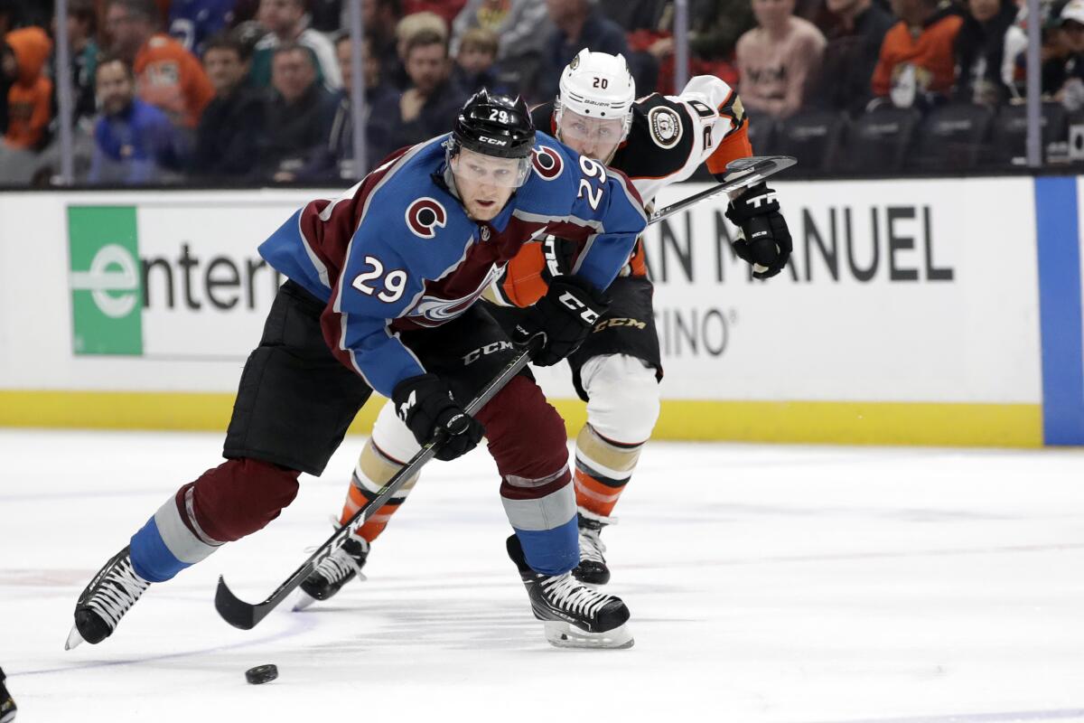 Avalanche center Nathan MacKinnon is chased by Ducks left wing Nicolas Deslauriers during the first period of a game Feb. 21 at Honda Center.