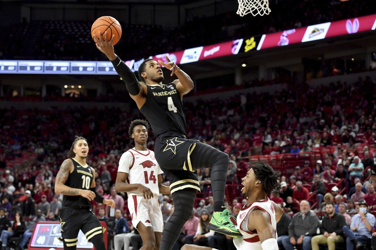 Vanderbilt guard Jordan Wright (4). Is fouled by Arkansas guard Stanley Umude (0) as he drives to the hoop during the second half of an NCAA college basketball game Tuesday, Jan. 4, 2022, in Fayetteville, Ark. (AP Photo/Michael Woods)