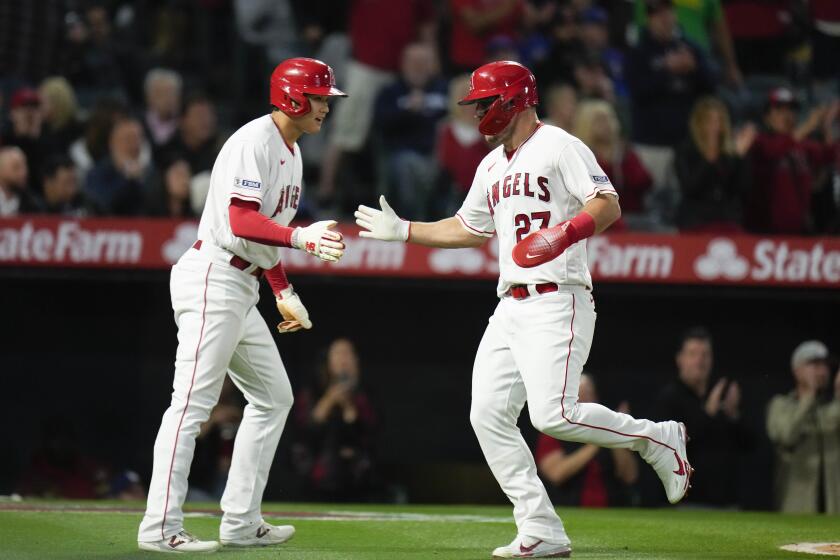 Angels' Shohei Ohtani, left, and Mike Trout celebrate after scoring against the Chicago Cubs on June 6, 2023, in Anaheim.