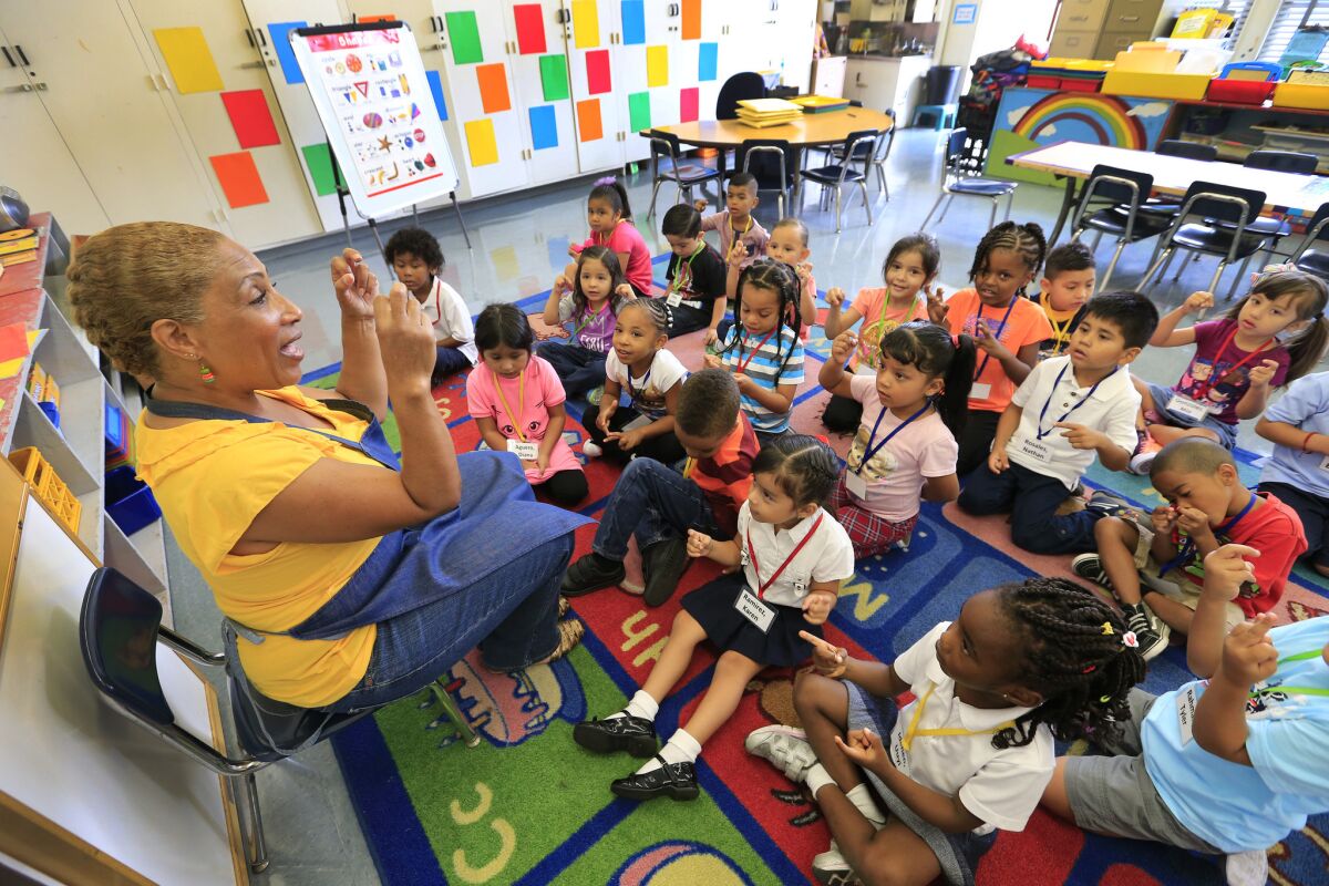 Children in L.A. Unified School District's expanded transitional kindergarten program join in a song with teacher Lisa Harmison during their first day of school at 186th Street Elementary in Gardena.