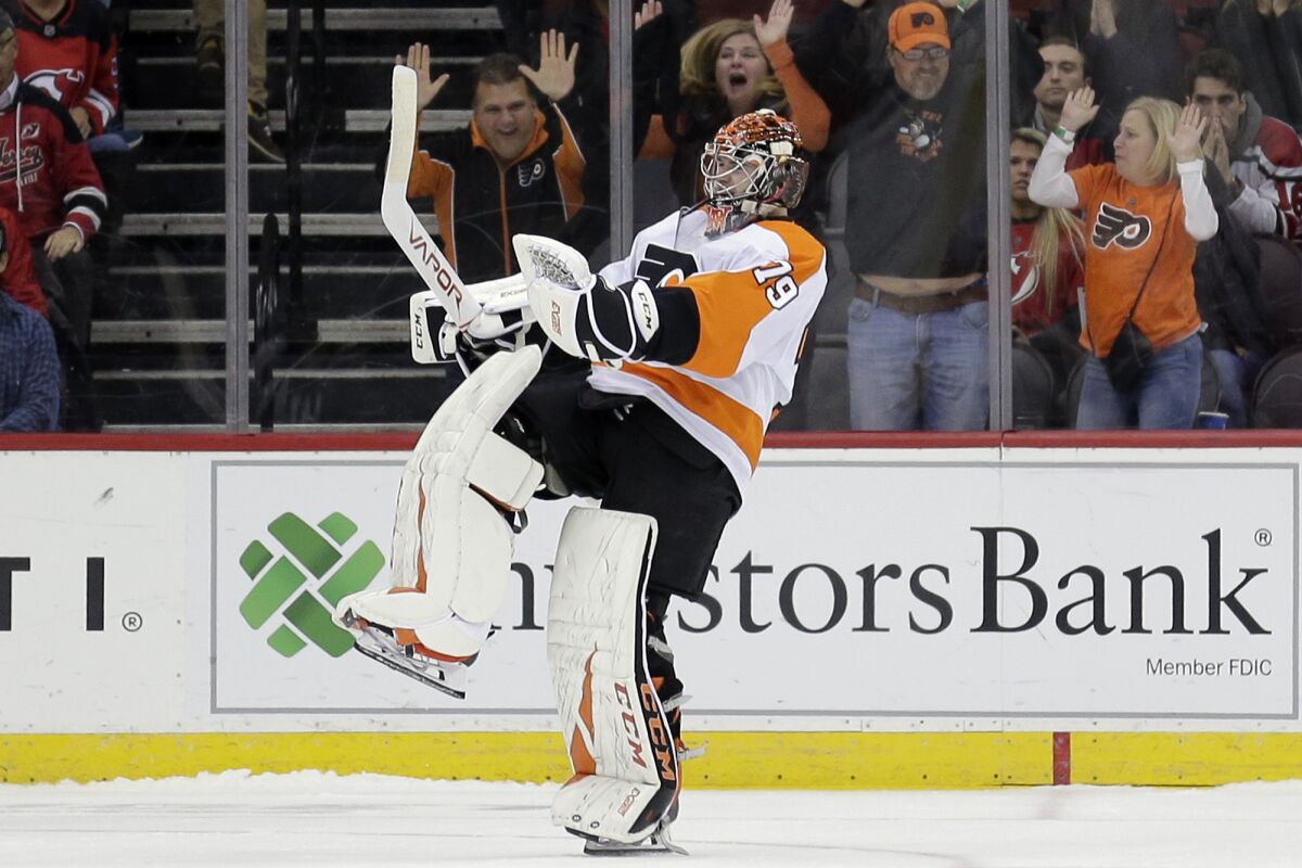 FILE - Philadelphia Flyers goaltender Carter Hart reacts after New Jersey Devils' Taylor Hall missed the last shot of a shootout in an NHL hockey game in Newark, N.J., in this Friday, Nov. 1, 2019, file photo. The Flyers won 4-3. The Flyers are counting on 22-year-old goalie Carter Hart to lead them to the title. (AP Photo/Seth Wenig, File)