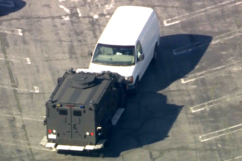Torrance police surround a white van in a parking lot near the Del Amo mall.