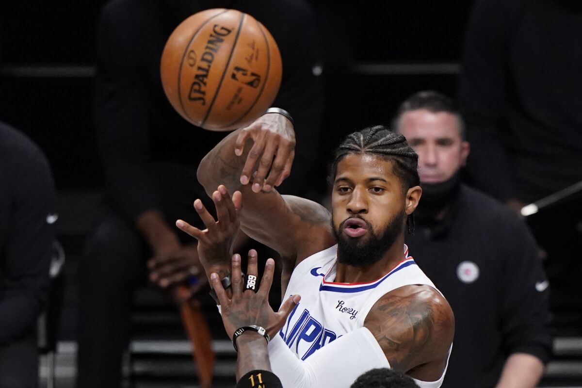 Clippers guard Paul George passes the ball.