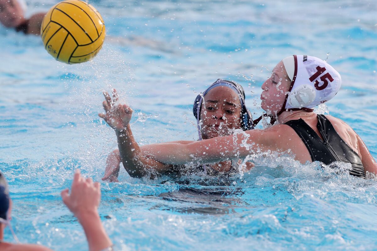 Newport Harbor's Angie Peterson, center, passes the ball defended by Laguna Beach's Kara Carver during Wednesday's match.