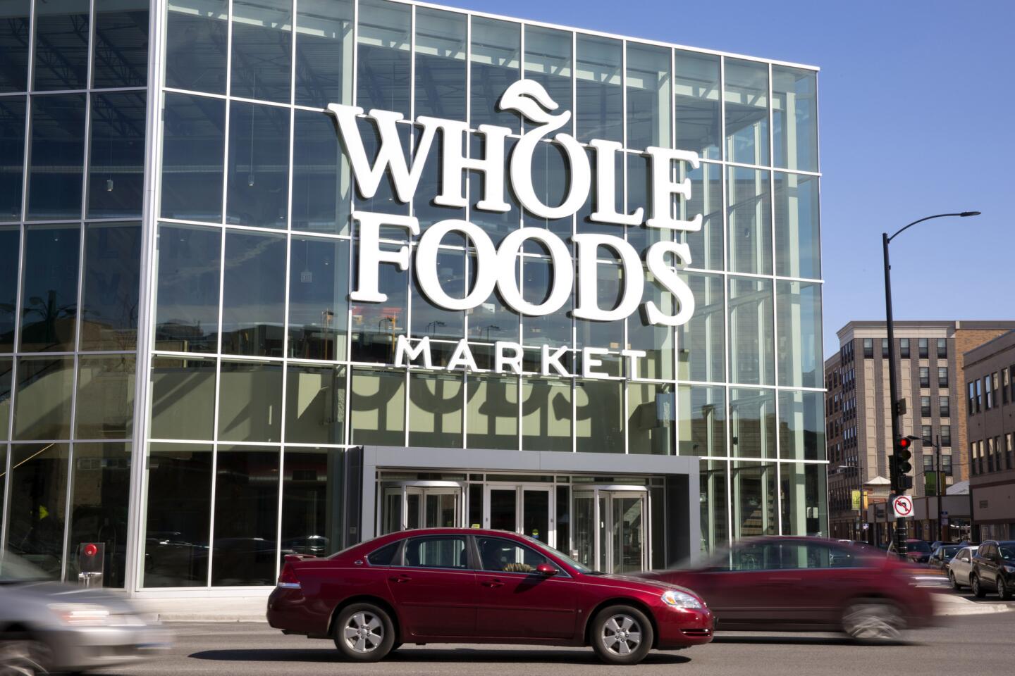 Cars pass the new Whole Foods Market March 10, 2017, in the Lakeview neighborhood of Chicago. The grocery chain, known for its organic options, had been facing increased pressure from rivals. Its sale to Amazon is expected to close in the second half of 2017.