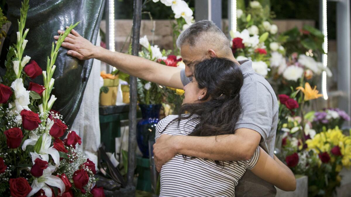 Romulo Avelica Gonzalez hugs his niece, Diana Vargas, as he prays at a shrine to St. Jude the Apostle at Mission San Conrado after being released.