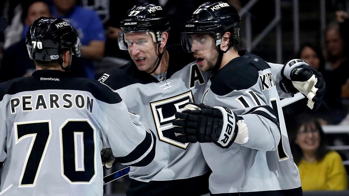 Kings center Anze Kopitar (11) celebrates with teammates Tanner Pearson and Jeff Carter after scoring against the Capitals during the second period Saturday.