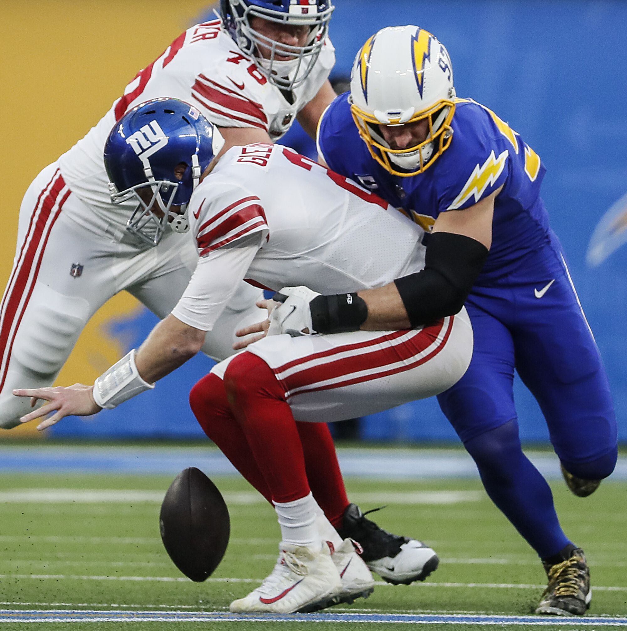 Chargers defensive end Joey Bosa, right, knocks the ball from New York Giants quarterback Mike Glennon.